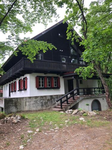 白马村House of Finn Juhl Hakuba的房屋设有红色窗户和阳台