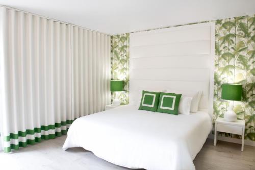 普拉亚达维埃拉Hotel Cristal Praia Resort & SPA的白色卧室配有白色的绿色床