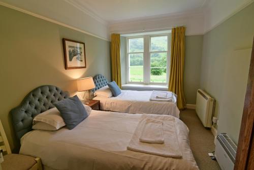 ChesthillGardeners Cottage的酒店客房设有两张床和窗户。