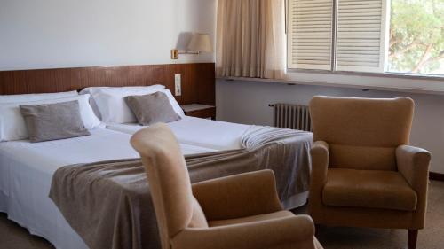 卡尔德斯德马拉维亚普拉茨水疗酒店的配有一张床和一把椅子的酒店客房