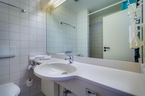阿尔滕堡阿斯特酒店的白色的浴室设有水槽和镜子