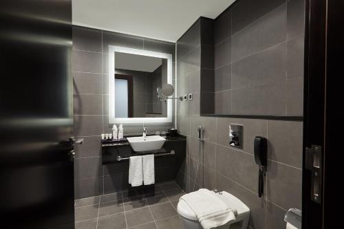 迪拜Park Regis Business Bay的一间带水槽、卫生间和镜子的浴室