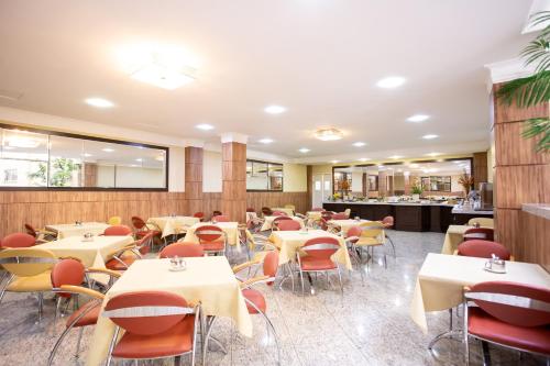 蓬塔格罗萨Barbur Center Hotel的空的饭厅,配有桌椅