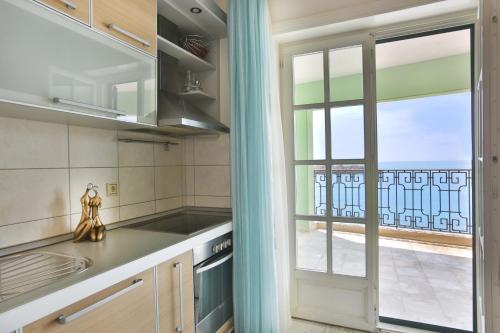 斯韦蒂·斯特凡Montesan Beach Apartments Sveti Stefan的厨房设有窗户,享有阳台的景致。