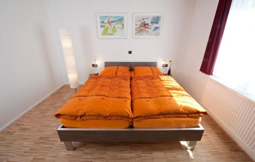 菲尔德施塔特梅林酒店的一张带橙色床单的大床