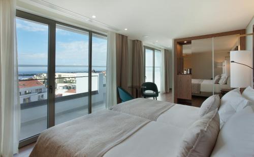 丰沙尔TURIM Santa Maria Hotel的酒店客房设有一张床和一个大窗户