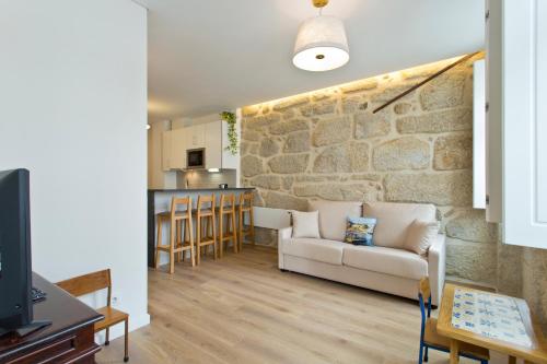 加亚新城Estrela de Gaia Apartments的带沙发和石墙的客厅