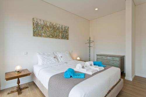 加亚新城Estrela de Gaia Apartments的卧室配有白色床和蓝色毛巾