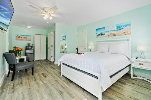 好莱坞好莱坞海滩精品套房的卧室配有白色的床、书桌和椅子