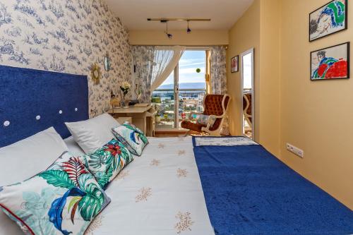 波尔托辛Noia Compostellae Beach的一间卧室配有一张带蓝色床头板的床和窗户