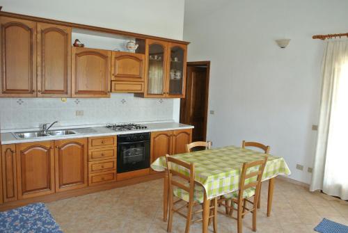 圣特奥多罗火烈鸟度假屋的厨房配有木制橱柜和桌椅