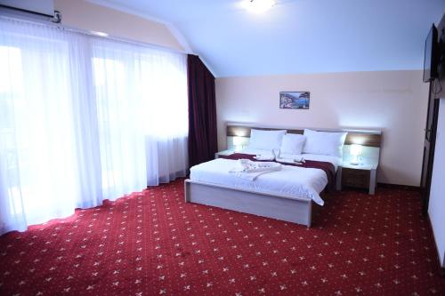 百乐费利克斯Vila Elysee的酒店客房,配有床铺和红地毯