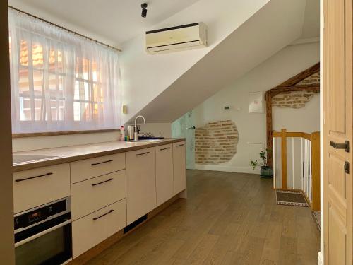 维尔纽斯维尔纽斯比利斯街非常公寓的一间厨房,配有白色的橱柜和大窗户
