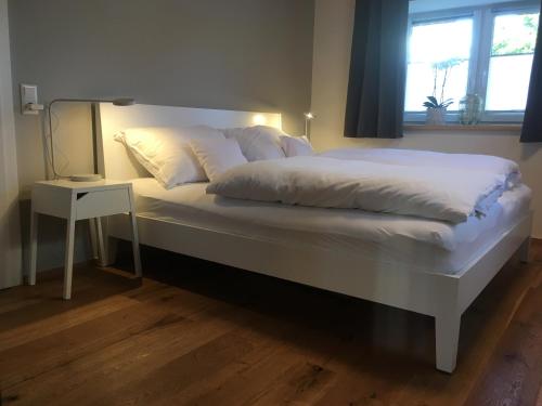 格齐斯Wohnung in zentraler Lage im Rheintal的一张配有白色床单和床头柜的大床