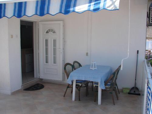 苏佩塔尔Apartment Slavica - Apartment with large terrace的一张桌子,上面有椅子和蓝桌布