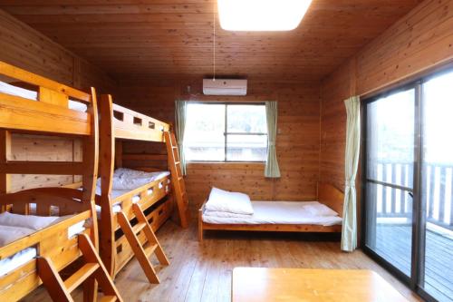屋久岛Maetakeso的小木屋内带双层床的客房