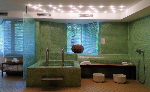 斯图加特relexa Waldhotel Schatten Stuttgart的绿色浴室设有浴缸和水槽