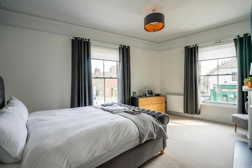 约克123 Nunnery Lane的一间卧室设有一张床和两个窗户。