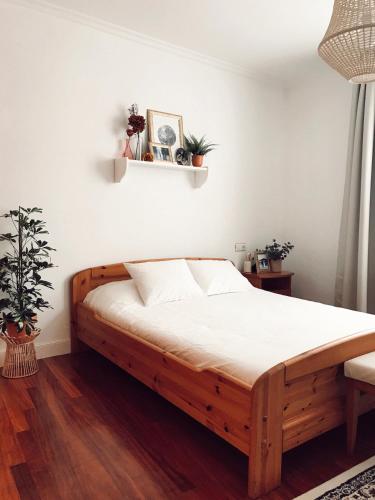 蒙达卡Apartamento en el autentico corazón de Mundaka的一间卧室配有一张带白色床单的木床