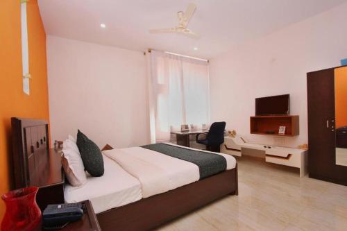 德瓦纳哈利-班加罗尔Airport Residency的一间卧室配有一张床、一张书桌和一台电视