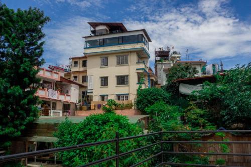 加德满都旺达瑟斯特旅馆的一座山丘上的建筑,前面有树木