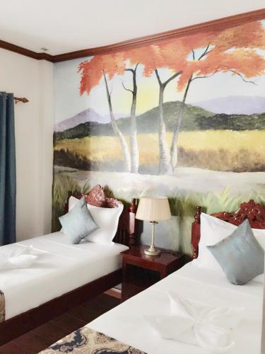 科隆Blue Waters Inn Coron Palawan的一间卧室配有两张床,墙上挂着一幅画