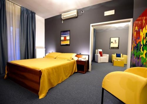 阿斯蒂卡斯宜纳勒恩奥沃酒店的一间卧室配有黄色的床和黄色的椅子