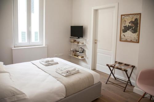佛罗伦萨Pietrapiana34 Boutique Apartments的白色卧室配有床和椅子