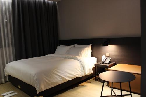 庆州Rivertain Hotel Gyeongju的酒店客房配有一张床铺、一张桌子和一张书桌。