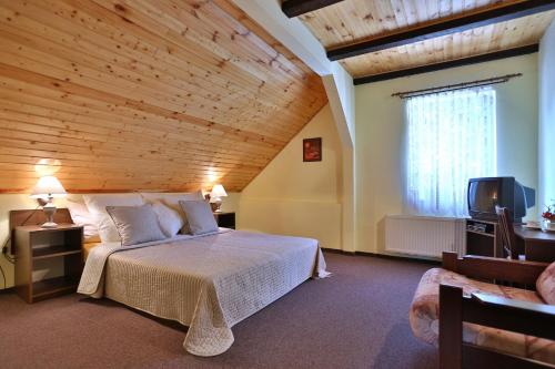 PerninkTradice (U Bendů)的一间卧室设有一张带木制天花板的大床