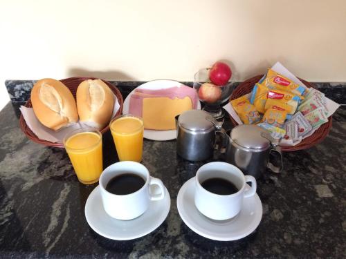 瓜鲁柳斯Motel Emoções de Guarulhos的一张桌子,上面放着两杯咖啡和面包