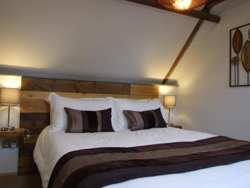 莱德林赫The Barn的一间卧室配有一张大床和木制床头板