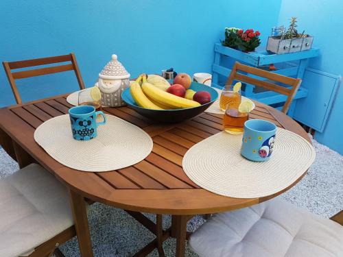 托里格兰德The Yellow House IUN P3446的一张木桌,上面放着两杯和一碗水果