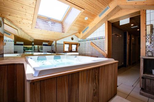 莱热贝尔维尤酒店的配有木制天花板的客房内的大浴缸