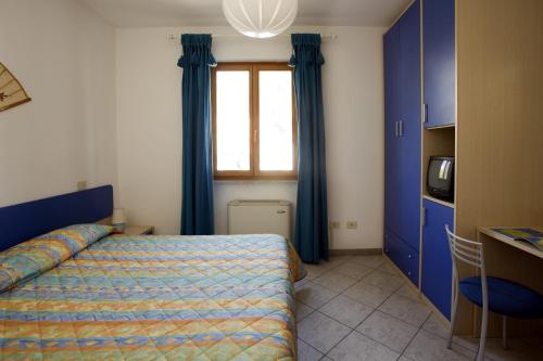波蒙特Casa degli Agrumi的一间卧室配有一张带蓝色窗帘的床和一扇窗户