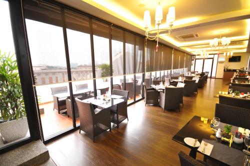 马六甲马六甲斯特林精品酒店的餐厅设有桌椅和大窗户。