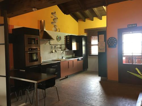 MartiherreroCASA RURAL ANTONIO的厨房设有黑色和橙色的墙壁和桌子