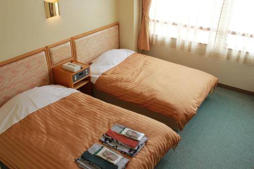那智胜浦町Manseiro的酒店客房设有两张床和窗户。