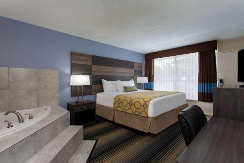 CherawBaymont by Wyndham Cheraw的酒店客房配有一张床和浴缸。