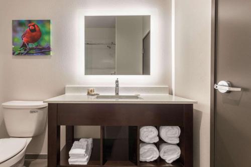 布卢明顿La Quinta Inn and Suites by Wyndham Bloomington的浴室设有水槽和一堆毛巾