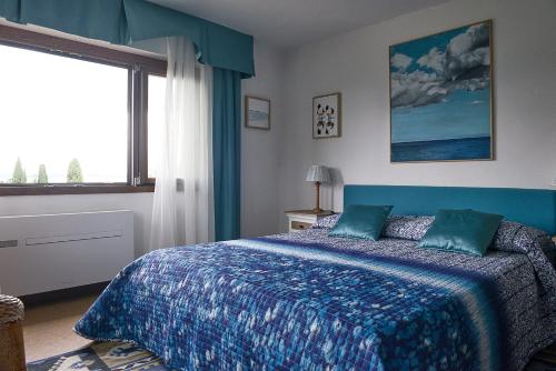 西尔米奥奈Villa Paradiso的一间卧室配有一张带蓝色毯子的床和窗户。