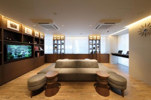 东京东京八重洲站京王普雷索经济型酒店的带沙发、凳子和电视的客厅