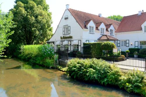 卡斯特尔莱De Watermolen的前面有一条河的房子