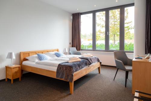 帕德博恩Hotel Vivendi的一间卧室设有一张床和一个大窗户