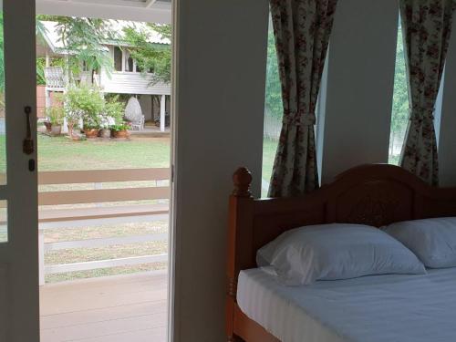 大城Baan Suan Yensabai @Ayutthaya的卧室配有滑动玻璃门旁边的床