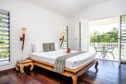 维拉港热带泻湖公寓式酒店的带阳台的客房内设有一间带大床的卧室