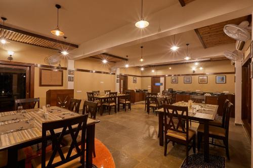 VelavadarBlackbuck Safari Lodge Velavadar的一间在房间内配有桌椅的餐厅