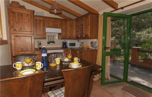 FirgasCasa Rural en medio del bosque, El Lance的厨房配有木制橱柜和一张带食物的桌子。