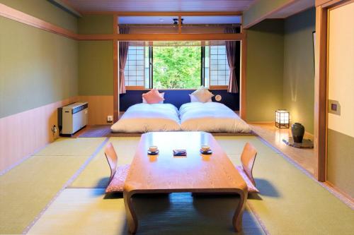 藏王温泉Meitoya So的卧室配有两张床和一张桌子,位于中间