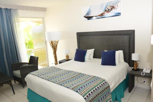 哥西尔Hotel Fleur d'Epee - Plage de Bas du Fort的一间卧室配有一张带蓝色枕头的大床